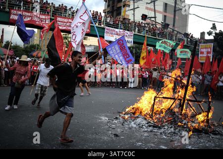 30 novembre 2013 - Manila, Filippine - i manifestanti ballano intorno a un'effigie ardente raffigurante il presidente Aquino durante una manifestazione fuori dal palazzo presidenziale di Manila, Filippine, 30 novembre 2013. I manifestanti hanno segnato il 150° anniversario della nascita del nazionalista filippino Andres Bonifacio con proteste che hanno sbattuto la lenta risposta dell'amministrazione Aquino nell'aiutare le vittime del recente tifone Haiyan, che ha devastato parti delle Filippine centrali e ha lasciato più di 5.000 morti. (Immagine di credito: © Ezra Acayan/ZUMAPRESS.com) Foto Stock