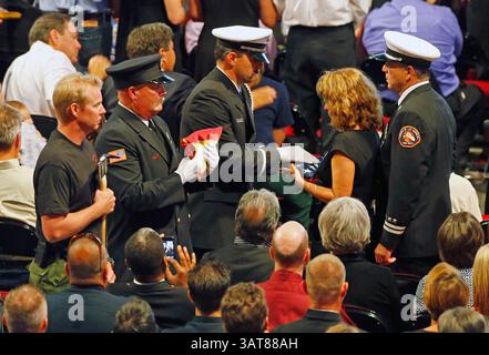9 luglio 2013 - Prescott Valley, Arizona, Stati Uniti - una guardia d'onore presenta il cappellino antincendio LACO, JOE WOYJECK e la sua famiglia. Con una bandiera americana in onore del figlio Kevin Woyjeck durante un servizio commemorativo al Tim's Toyota Center per 19 pompieri di Granite Mountain uccisi il 30 giugno, combattendo l'incendio di Yarnell Hill. (Immagine di credito: © David Kadlubowski-POOL/The Arizona Republic/ZUMAPRESS.com) Foto Stock