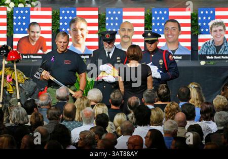 9 luglio 2013 - Prescott Valley, Arizona, Stati Uniti - una guardia d'onore presenta alle famiglie una bandiera americana durante un servizio commemorativo al Tim's Toyota Center per 19 pompieri di Granite Mountain uccisi il 30 giugno, combattendo l'incendio di Yarnell Hill. (Immagine di credito: © David Kadlubowski-POOL/The Arizona Republic/ZUMAPRESS.com) Foto Stock