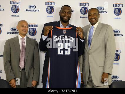 10 luglio 2013 - Charlotte, NC, USA - al Jefferson regge la sua maglia dei Charlotte Bobcats mentre si trova con il General manager Rich Cho, a sinistra e presidente delle operazioni di basket Rod Higgins, a destra, durante una conferenza stampa annunciando che la squadra aveva firmato il centro free agent della Time Warner Cable Arena di Charlotte, Carolina del Nord, mercoledì 10 luglio 2013. (Immagine di credito: © David T. Foster III/MCT/ZUMAPRESS.com) Foto Stock