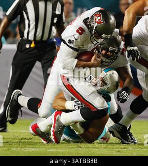 24 agosto 2013 - Miami, FL, USA - il quarterback dei Tampa Bay Buccaneers Josh Freeman (5) viene svincolato per una perdita di due yard dal defensive end dei Miami Dolphins Jared Odrick (98) nel secondo quarto al Sun Life Stadium di Miami, Floriida, sabato 24 agosto 2013. (Immagine di credito: © Daniel Wallace/MCT/ZUMAPRESS.com) Foto Stock