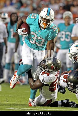 24 agosto 2013 - Miami, FL, USA - Daniel Thomas dei Miami Dolphins trascina Lavonte David dei Tampa Bay Buccaneers nel primo quarto al Sun Life Stadium di Miami, Florida, sabato 24 agosto 2013. I Buccaneers sconfissero i Dolphins, 17-16. (Immagine di credito: © Charles Trainor Jr/MCT/ZUMAPRESS.com) Foto Stock