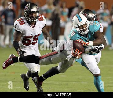 24 agosto 2013 - Miami, FL, USA - Brandon Gibson dei Miami Dolphins prende la palla mentre Rashaan Melvin dei Tampa Bay Buccaneers lo affronta nel secondo quarto al Sun Life Stadium di Miami, Florida, sabato 24 agosto 2013. I Buccaneers sconfissero i Dolphins, 17-16. (Immagine di credito: © Charles Trainor Jr/MCT/ZUMAPRESS.com) Foto Stock