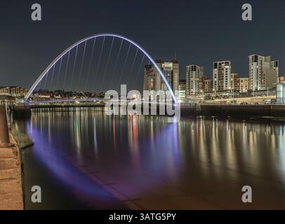 Newcastle, Regno Unito - 13 aprile 2025 - paesaggio notturno dell'iconico ponte del millennio di gateshead che attraversa il fiume Tyne e i mulini a farina del Baltico con Dark S. Foto Stock