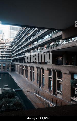 Londra, Regno Unito - 28 settembre 2024: Balconi residenziali brutalisti e passerella del canale di Gilbert House nella Barbican Estate, City of London, circondata Foto Stock