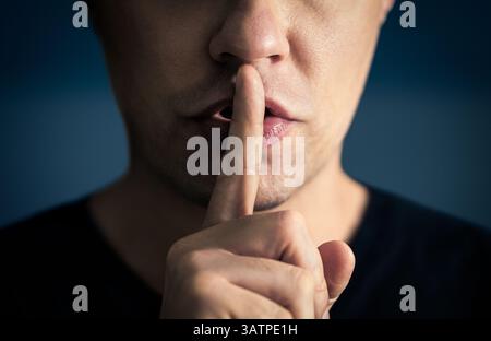 Silenzio e silenzio! Il segreto di un uomo. Accidenti. Dito e bocca. Zitto. Gesto riservato silenzioso. Labbri sigillati. Libertà di parola, censura, tabù. Foto Stock