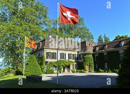 Castello di Penthes con la bandiera nazionale svizzera e la bandiera del Cantone di Ginevra nel parco Domaine de Penthes, Pregny-Chambesy, Ginevra, Switze Foto Stock