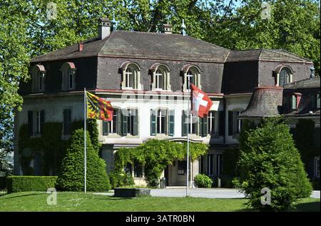 Castello di Penthes con la bandiera nazionale svizzera e la bandiera del Cantone di Ginevra nel parco Domaine de Penthes, Pregny-Chambesy, Ginevra, Switze Foto Stock