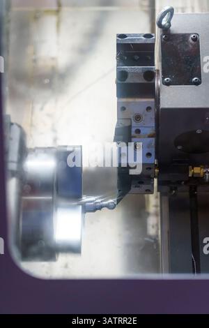 Un tornio CNC forma e taglia le parti metalliche dell'albero. mandrino, fresa e tornio in funzione Foto Stock