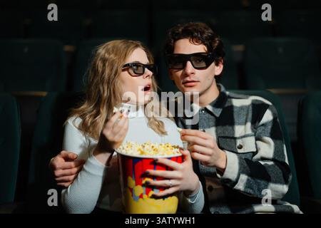 La coppia ama la serata al cinema con popcorn e bicchieri 3D. Foto Stock
