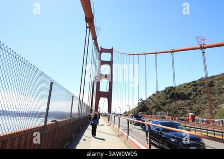 Colonna rossa luminosa del Golden Gate Bridge contro il cielo blu. Foto Stock