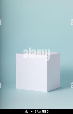 Cubo bianco su sfondo blu. Mock-up minimo per i tuoi prodotti. Foto Stock