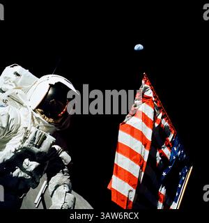 12 dicembre 1972 - Taurus Littrow, Stati Uniti d'America - l'astronauta e scienziato della NASA Apollo 17 Harrison Schmitt si trova accanto alla bandiera americana durante la prima EVA sulla superficie lunare con la terra vista in lontananza il 12 dicembre 1972. Apollo 17 è l'ultima missione di atterraggio lunare prevista. (Immagine di credito: © Gene Cernan/Planet Pix via cavo ZUMA) Foto Stock