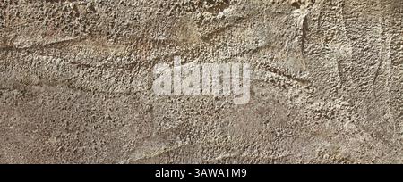 Una vecchia struttura grigia della parete, sfondo. Vista su cemento grezzo. Antica superficie grigia, sfondo. Superficie ruvida e irregolare di colore grigio con motivo astratto Foto Stock