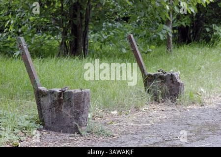 Resti di vecchie panchine in legno demolito, grande parco pubblico abbandonato orizzontale e dettagliato dettaglio dettaglio dettaglio dettaglio dettaglio sedili vintage, gambe in cemento in rovina grigio Foto Stock