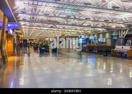 Ampia vista interna del terminal JFK con area salotto, negozio duty free, cartelli per cancelli e distributori automatici. New York. STATI UNITI. Foto Stock