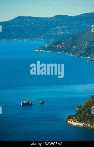 Affacciato sul Lago maggiore dal belvedere di Campagnano , oltre alla chiesa di San Rocco a Campagnano, Varese. I Castelli di Cannero sono tre isolotti rocciosi del Lago maggiore nel nord Italia. Si trovano al largo della costa di Cannero Riviera, mentre amministrativamente fanno parte del comune di Cannobio. Sono noti come castelli, o castelli, in riconoscimento delle antiche fortificazioni in rovina che si trovano su due di esse. Sono tutto ciò che rimane della Rocca Vitaliana costruita tra il 1519 e il 1521 Foto Stock