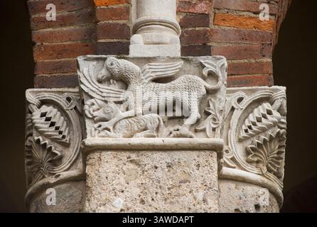 Dettaglio della muratura scolpita in pietra sull'esterno della Basilica di Sant'Ambrogio, Milano, Italia. Colonne in pietra con disegni di animali stilizzati Foto Stock