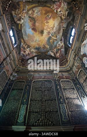 San Bernardino alle ossa è una chiesa di Milano meglio conosciuta per il suo ossario, una piccola cappella laterale decorata con numerosi teschi e ossa umani. Nel 1210, quando un cimitero adiacente finì lo spazio, fu costruita una stanza per contenere le ossa. Una chiesa fu annessa nel 1269. Rinnovato nel 1679, è stato distrutto da un incendio nel 1712. Una nuova chiesa più grande fu poi annessa a quella più antica e dedicata a San Bernardino da Siena. Il soffitto fu affrescato nel 1695 da Sebastiano Ricci Chiesa di San Bernardino alle ossa, Piazza Santo Stefano, Milano, Italia Foto Stock