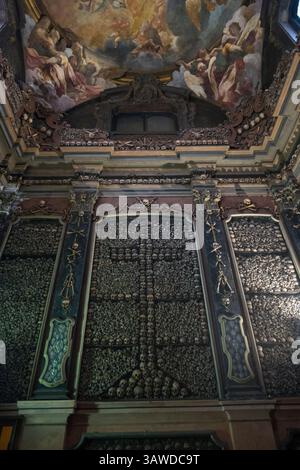 San Bernardino alle ossa è una chiesa di Milano meglio conosciuta per il suo ossario, una piccola cappella laterale decorata con numerosi teschi e ossa umani. Nel 1210, quando un cimitero adiacente finì lo spazio, fu costruita una stanza per contenere le ossa. Una chiesa fu annessa nel 1269. Rinnovato nel 1679, è stato distrutto da un incendio nel 1712. Una nuova chiesa più grande fu poi annessa a quella più antica e dedicata a San Bernardino da Siena. Il soffitto fu affrescato nel 1695 da Sebastiano Ricci Chiesa di San Bernardino alle ossa, Piazza Santo Stefano, Milano, Italia Foto Stock