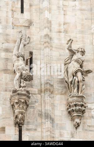 Sant'Agapito di Palestrina, situato all'esterno del Duomo di Milano. Sant'Agapito fu un martire adolescente del III secolo, torturato per essere cristiano sotto l'imperatore Aureliano. ? La statua lo raffigura capovolto, forse l'interpretazione dell'artista della sua tortura. Fu gettato alle bestie selvatiche, che si rifiutarono di fargli del male, e poi fu decapitato. ? La statua fu realizzata da Marco Antonio Prestinari intorno al 1605-1607 ed è realizzata in marmo di Candoglia. Milano, Italia Foto Stock