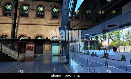 La moderna facciata in vetro riflette la vecchia facciata in mattoni con colorate vetrate colorate a Siviglia, Spagna - SIVIGLIA, SPAGNA - 25 MARZO 2025 Foto Stock