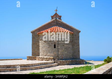 Chiesa di Santa Sava, un luogo di culto serbo ortodosso che si affaccia su Sveti Stefan lungo la costa del Mar Adriatico in Montenegro Foto Stock
