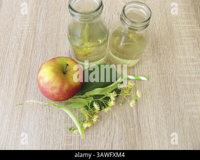 Limonata appena preparata con fiori di lime e succo di mela in piccole bottiglie Foto Stock