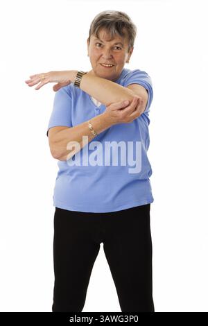 Donna anziana che fa esercizi di stretching - donna anziana isolata che fa esercizi di stretching - isolata Foto Stock