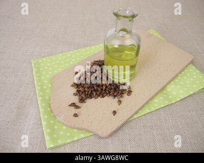 Olio sano di semi d'uva, olio dai semi d'uva in una bottiglia di vetro Foto Stock