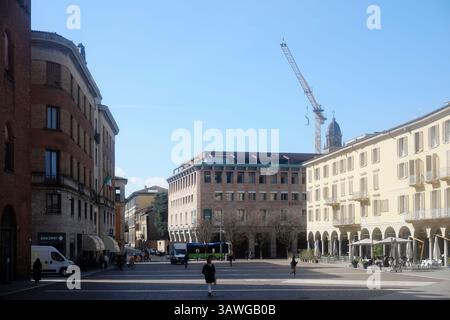 Cremona, Italia 15 marzo 2025 due studenti camminano in Piazza Stradivari a Cremona, Lombardia, Italia, una piazza con posti a sedere all'aperto, una statua, e. Foto Stock