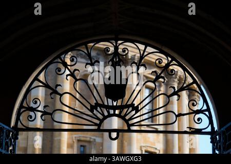 Griglia in ferro battuto nell'intima porta d'ingresso tra due dei monumenti storici più importanti di Oxford: La Bodleian Library e Radcliiffe Square. La Bodleian Library, la principale biblioteca di ricerca dell'Università di Oxford, è una delle più antiche biblioteche d'Europa. Con oltre 12 milioni di oggetti, è la seconda biblioteca più grande in Gran Bretagna dopo la British Library. Radcliffe Square, con la famosa Radcliffe camera al centro, vista qui. Questo è affiancato dai collegi All Souls e Brasenose, nonché dalla chiesa di Santa Maria. Foto Stock