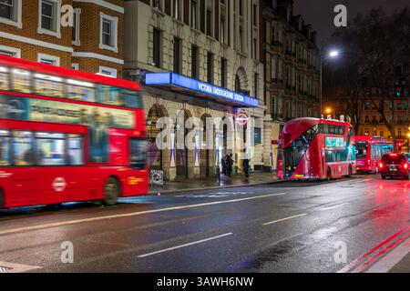 Ingresso alla stazione della metropolitana Victoria con autobus rossi di notte, Londra Foto Stock