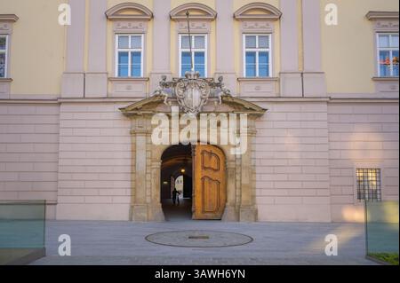 Scoprite l'impressionante Landhaus di Linz, Austria, con la sua grande entrata con una porta in legno splendidamente realizzata. Questo edificio storico si riflette Foto Stock