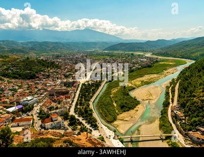 Nell'Albania sud-occidentale, una vista panoramica di Berat si estende lungo il fiume Osum, mostrando tetti a strati, echi ottomani e il monte Tomorr nel Th Foto Stock