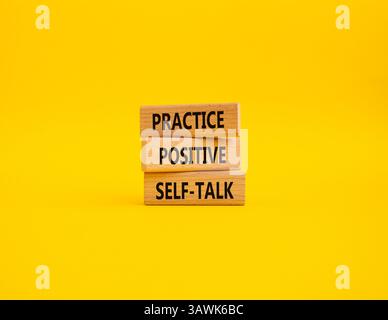 Esercitarsi con il simbolo di autoapprendimento positivo. Le parole concettuali esercitano un'autocomunicazione positiva su blocchi di legno. Bellissimo sfondo giallo. POS. Business e pratica Foto Stock
