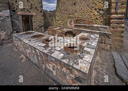 Ercolano, Italia - 26 giugno 2018: Bancone di cibo antico (Thermopolium) a Ercolano (Ercolano) con pentole in ceramica per mantenere caldo il cibo. Foto Stock