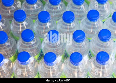 Vista ad angolo elevato di file di bottiglie d'acqua in plastica trasparente da 500 ml con tappi elicoidali blu. Foto Stock