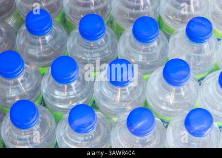 Vista ad angolo elevato di file di bottiglie d'acqua in plastica trasparente da 500 ml con tappi elicoidali blu. Foto Stock