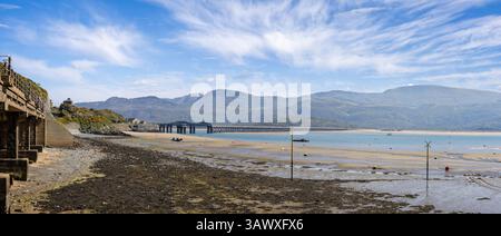 Vista panoramica del ponte di Barmouth e dell'estuario di Mawddach durante la bassa marea con le montagne alle spalle di Barmouth, Galles, il 9 aprile 2025 Foto Stock