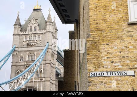 La Torre Sud del Tower Bridge di Londra con un cartello stradale dalla vicina strada, Shad Thames Foto Stock