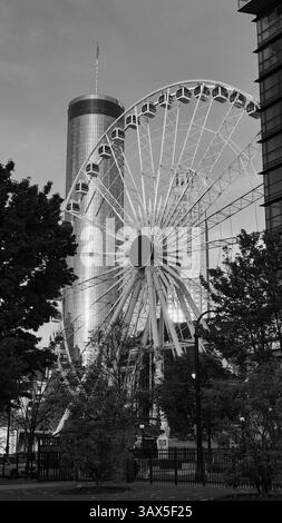 Atlanta, Stati Uniti: 19 aprile 2025: Foto in bianco e nero dello skyline del centro di Atlanta al tramonto, edifici, ruota panoramica e turisti che si godono un fresco sprin Foto Stock