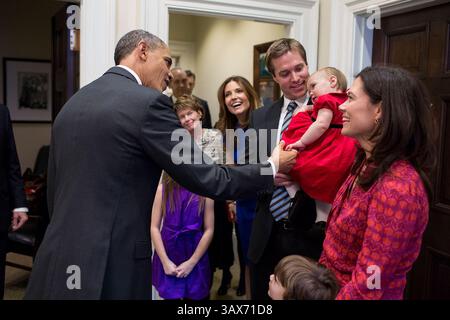 13 dicembre 2013 - Washington, DC, USA - il presidente degli Stati Uniti Barack Obama saluta la figlia di un membro dello staff in partenza presso l'Outer Oval Office della Casa Bianca il 13 dicembre 2013 a Washington, DC. Barack Hussein Obama II (nato il 4 agosto 1961) è il 44° presidente degli Stati Uniti. È il primo afroamericano ad essere eletto in carica e il primo presidente nato al di fuori degli Stati Uniti contigui. Nato a Honolulu, Hawaii, Obama si è laureato alla Columbia University e alla Harvard Law School. Ha lavorato come avvocato per i diritti civili e ha insegnato diritto costituzionale all'Università di Chicago Law Foto Stock