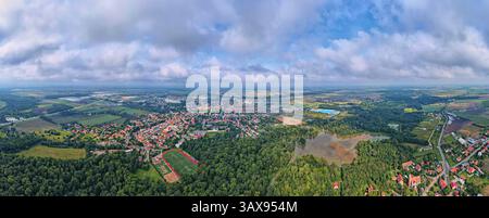 Vista aerea della piccola città circondata da foreste, terreni agricoli e aree allagate dopo una forte pioggia. Vista dall'alto del villaggio in Polonia. Orizzontale con resid Foto Stock