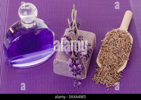 Essenza da bagno e sapone con lavanda su fondo viola essenza da bagno e sapone con lavanda su fondo viola Foto Stock