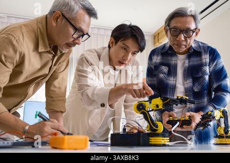 Gli ingegneri di asian robot ARM fanno brainstorming in officina per sviluppare tecnologie di controllo con lavoro di squadra e innovazione nella codifica Foto Stock