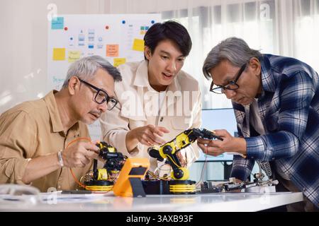 Gli ingegneri di asian robot ARM fanno brainstorming in officina per sviluppare tecnologie di controllo con lavoro di squadra e innovazione nella codifica Foto Stock