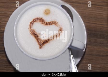 Schema cardiaco nella schiuma di latte in una tazza di caffè - primo piano Foto Stock