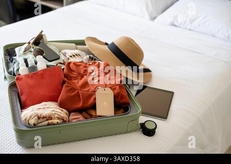 Valigia imballata per le vacanze di primavera a letto Foto Stock