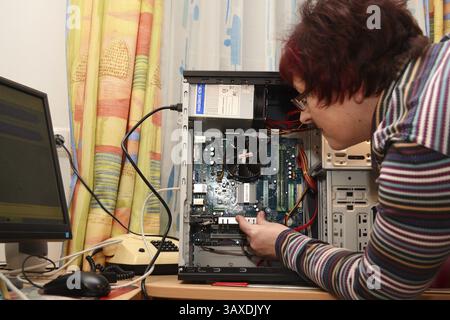 Il tecnico di rete installa la scheda grafica nel PC Foto Stock